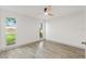 Bright bedroom with wood-look flooring, ceiling fan, and double-hung windows providing ample natural light at 7400 Belvedere Ter, New Port Richey, FL 34655