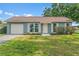 Charming one-story home with a well-manicured lawn, attached garage, and shuttered windows at 7400 Belvedere Ter, New Port Richey, FL 34655