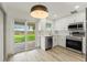 Modern kitchen with stainless steel appliances, white cabinets, and sliding glass door to the backyard at 7400 Belvedere Ter, New Port Richey, FL 34655