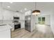 Bright kitchen featuring stainless steel appliances, white cabinets, and modern countertops at 7400 Belvedere Ter, New Port Richey, FL 34655