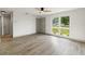 Spacious living room with modern wood-look flooring, lots of natural light, and a ceiling fan at 7400 Belvedere Ter, New Port Richey, FL 34655
