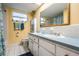 Bright bathroom featuring a double vanity with white cabinets, a large mirror and white tile flooring at 8956 124Th Way, Seminole, FL 33772