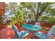 A vibrant dining table sits on this spacious back deck, surrounded by lush trees at 904 E Patterson St, Tampa, FL 33604