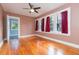 Bedroom with hardwood floors, a ceiling fan, and windows with red curtains at 904 E Patterson St, Tampa, FL 33604