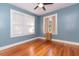 Bedroom with hardwood floors, ceiling fan, and two windows with blinds and curtains at 904 E Patterson St, Tampa, FL 33604