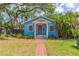 Charming blue single-story home with a red front door and a brick walkway at 904 E Patterson St, Tampa, FL 33604