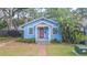 Charming blue home featuring a cozy front porch, red door, and well-maintained yard at 904 E Patterson St, Tampa, FL 33604