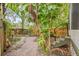 Backyard brick pathway leads to cozy seating area surrounded by lush greenery at 916 E Broad St, Tampa, FL 33604