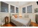 Well-lit bedroom with three windows, hardwood floors, and comfortable furnishings at 916 E Broad St, Tampa, FL 33604