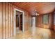 Wood paneled bedroom featuring a window, ceiling fan, closet, and hardwood floors at 916 E Broad St, Tampa, FL 33604