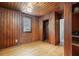 Wood paneled bedroom featuring a window, air conditioner, and access to a bathroom at 916 E Broad St, Tampa, FL 33604