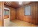 Wood paneled bedroom featuring a window, hardwood floor, and view to the next room at 916 E Broad St, Tampa, FL 33604