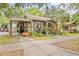 Quaint home exterior featuring a carport, lovely landscaping, and a cozy front porch, adding character to the property at 916 E Broad St, Tampa, FL 33604