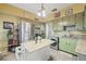 Bright kitchen featuring green cabinets, stainless steel appliances, an island, and granite countertops at 916 E Broad St, Tampa, FL 33604