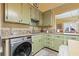 The kitchen features granite countertops, green cabinets, stainless steel sink and modern stainless steel washer at 916 E Broad St, Tampa, FL 33604