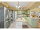 Open kitchen featuring stainless steel appliances, butcher block island, granite countertops and green cabinets at 916 E Broad St, Tampa, FL 33604