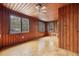 A wood paneled living room featuring a ceiling fan and natural light from multiple windows at 916 E Broad St, Tampa, FL 33604
