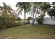 A backyard overlooking a lake with shrubbery and palm trees on a sunny day at 9816 Crofton Ln, Port Richey, FL 34668