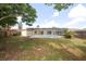 A backyard with patchy grass and a screened in pool attached to the house at 9816 Crofton Ln, Port Richey, FL 34668