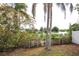 A backyard overlooking a lake with shrubbery and palm trees on a sunny day at 9816 Crofton Ln, Port Richey, FL 34668
