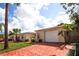 A single Gathering home showcasing a well-kept front yard and brick paved driveway at 9816 Crofton Ln, Port Richey, FL 34668