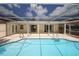 Sparkling pool with an enclosed screen, open patio, and clear blue water at 9816 Crofton Ln, Port Richey, FL 34668