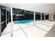 A screened in patio with a clean swimming pool, steel rails, and bright, white floors at 9816 Crofton Ln, Port Richey, FL 34668
