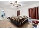 Bedroom with a ceiling fan, window with curtains, and a bed with a patterned blanket at 3509 San Moise St, Plant City, FL 33567