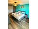 Stylish bedroom with a modern bed, unique barn door closet, and eye-catching turquoise accent wall at 10411 Summerview Cir, Riverview, FL 33578