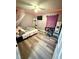 Cozy bedroom with wood-look flooring and neutral-toned walls, illuminated by unique ambient lighting at 10411 Summerview Cir, Riverview, FL 33578
