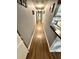 A long hallway featuring sleek, wood-look floors and neutral paint, leading to various rooms in the home at 10411 Summerview Cir, Riverview, FL 33578