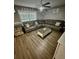 Spacious living room with a large sectional sofa and wood-look flooring at 10411 Summerview Cir, Riverview, FL 33578