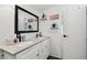 Bright bathroom featuring a double vanity, black fixtures, and decor shelves at 10501 Bay Hills Cir, Thonotosassa, FL 33592