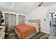 Charming bedroom featuring a tufted headboard, warm colored duvet, hardwood flooring, and sheer curtains at 10501 Bay Hills Cir, Thonotosassa, FL 33592