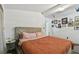 Bedroom featuring a tufted headboard, warm colored duvet, decorative pictures, and light gray hardwood flooring at 10501 Bay Hills Cir, Thonotosassa, FL 33592