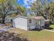 Single-story home featuring gray siding, well-maintained lawn, and mature trees providing shade at 10501 Bay Hills Cir, Thonotosassa, FL 33592