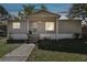 Charming single-story home featuring a covered porch, gray siding, and well-maintained landscaping at 10501 Bay Hills Cir, Thonotosassa, FL 33592