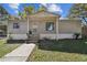 Inviting single-story home with a covered entryway, gray siding, and front yard greenery at 10501 Bay Hills Cir, Thonotosassa, FL 33592