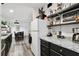 Bright kitchen with white appliances, dark cabinets, open shelving, and decorative accents at 10501 Bay Hills Cir, Thonotosassa, FL 33592