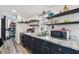 Galley kitchen with granite countertops, double sink, and open shelving at 10501 Bay Hills Cir, Thonotosassa, FL 33592