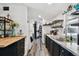 Galley kitchen with granite countertops, black cabinets, stainless steel sink, and open shelving at 10501 Bay Hills Cir, Thonotosassa, FL 33592