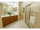 Bright bathroom with double sinks, wood cabinets and glass enclosed shower at 10716 Ashford Oaks Dr, Tampa, FL 33625