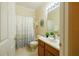 Bathroom with white tile, oak vanity and shower and tub combo at 10716 Ashford Oaks Dr, Tampa, FL 33625
