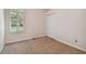 Small bedroom with neutral carpet, window with blinds, and closet at 10716 Ashford Oaks Dr, Tampa, FL 33625