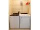 Laundry room with white washer and dryer and wire shelving at 10716 Ashford Oaks Dr, Tampa, FL 33625