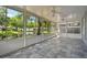 Enclosed patio with tiled flooring, ceiling fans, and views of the backyard and lake at 10716 Ashford Oaks Dr, Tampa, FL 33625
