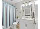 Charming bathroom with a toilet, vanity, marble countertop, and a shower with blue curtains at 11207 Donneymoor Dr, Riverview, FL 33569