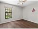Bright bedroom featuring hardwood floors, a ceiling fan, and a large window providing natural light at 11207 Donneymoor Dr, Riverview, FL 33569