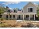 Charming two-story home with black-trimmed windows, pillars, and a landscaped front yard at 11207 Donneymoor Dr, Riverview, FL 33569