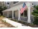 Charming front porch with white columns, a gray brick facade, decorative plants, and cozy seating at 11207 Donneymoor Dr, Riverview, FL 33569
